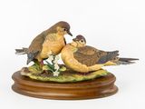 deux oiseaux perchés sur un socle en bois