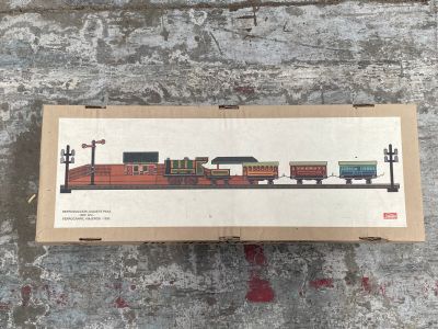 une boîte sur laquelle est représenté un train, posée par terre