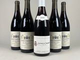 six bouteilles de vin sont alignées sur une table