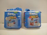 two packs of baby diapers sitting on top of a counter
