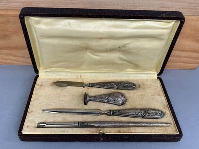 un service d'argenterie dans un coffret posé sur une table