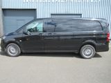 the black van is parked in front of a building in a parking lot