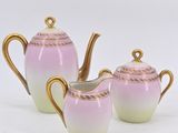 three pieces of pink and gold tea set on a white background