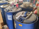 several blue barrels sitting on the floor in a garage