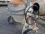 a cement mixer sitting in the middle of a parking lot