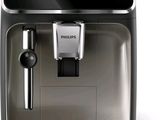 La machine à café est posée sur une surface blanche, à côté d'une tasse de café.