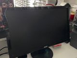 a computer desk with a monitor, keyboard, mouse and other items