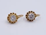 a pair of gold and diamond earrings