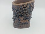 un petit vase orné d'un motif sculpté
