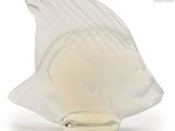 a glass figurine of a fish on a white background