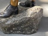 a bronze statue of a man standing on a rock