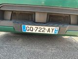 a close up of a green car with a license plate on it
