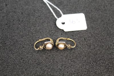 a pair of earrings with pearls and a price tag on a table