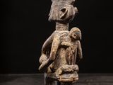 a wooden statue of a man with a bird on his shoulder