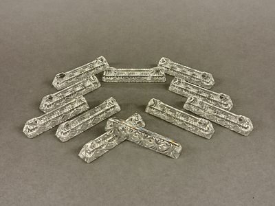 six silver plated metal clips on a gray surface
