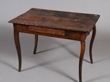 une vieille table en bois avec un tiroir en dessous, posée sur un sol gris