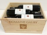 quatre bouteilles de vin dans un coffret en bois posé sur une table