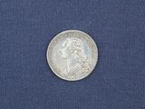a close up of a silver coin on a blue cloth