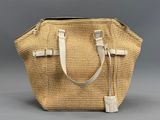 Ce grand sac fourre-tout en paille est doté d'une poignée à fermeture éclair et d'une bandoulière blanche