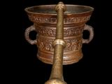 a large metal bowl with a wooden spoon in it
