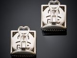 two silver cufflinks with a heart and a key on them