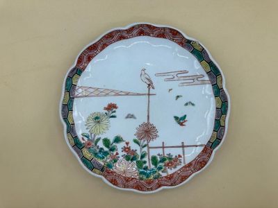 une assiette avec l'image d'un oiseau et de fleurs