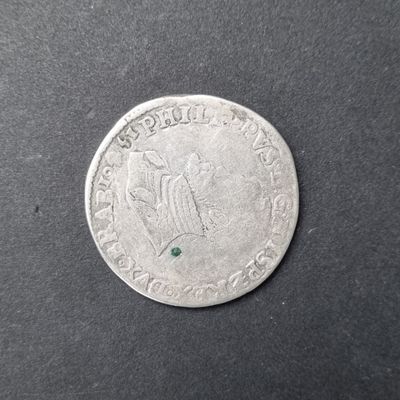 un gros plan d'une pièce de monnaie sur laquelle est sertie une pierre verte