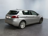 the back of a silver car in a room with a white wall