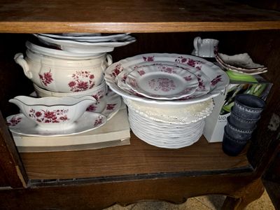 many plates and bowls sitting on a shelf in a cabinet