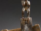 an image of a wooden sculpture of a person holding a cross