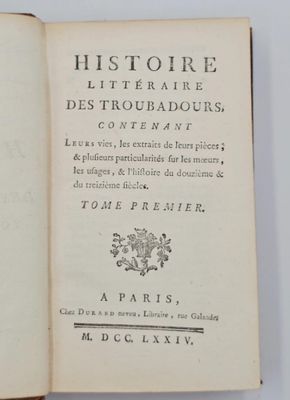 un livre ouvert posé sur une table à côté d'une tasse de café