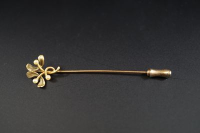 une broche en forme de fleur dorée sur un fond noir