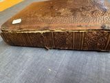 an old book sitting on the floor with a tag on it