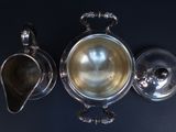 a silver tea pot and a silver teapot on a table