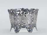 an ornate silver bowl with a flower design on a stand
