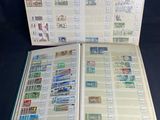 an open book with stamps on it sitting on top of a table