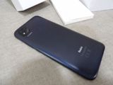 a black cell phone on a table next to an open book