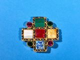 a close up of a colorful broochle on a blue surface