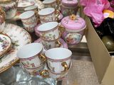 many cups and saucers sitting on a glass table