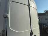 une camionnette blanche garée sur un parking aux côtés d'autres véhicules