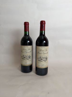 two bottles of red wine sitting next to each other on a table