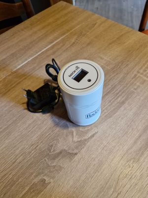 une tasse de café posée sur une table, à côté d'un téléphone portable