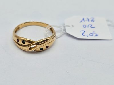 a close up of a gold ring on a white surface with a price tag