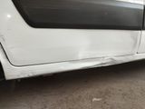 a white car that has been dented and is parked in a lot