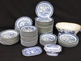 many blue and white plates and bowls on a black table