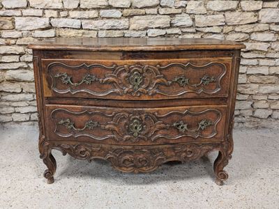 une vieille commode en bois ornée de sculptures élaborées sur le dessus