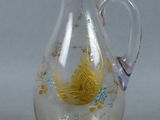 a glass pitcher with a gold and blue design on it
