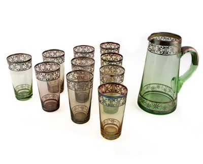 de nombreux verres de différentes couleurs et un pichet sur la table