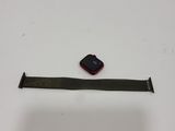 Une Apple Watch est posée sur une surface blanche, avec un bracelet noir.