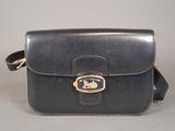 the small black leather bag has a gold buckle on the front